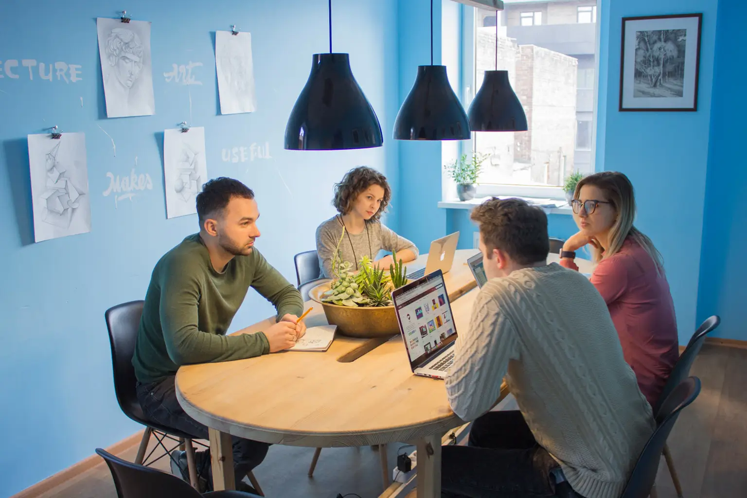 team meeting in a office with laptops and notes on digital marketing project.